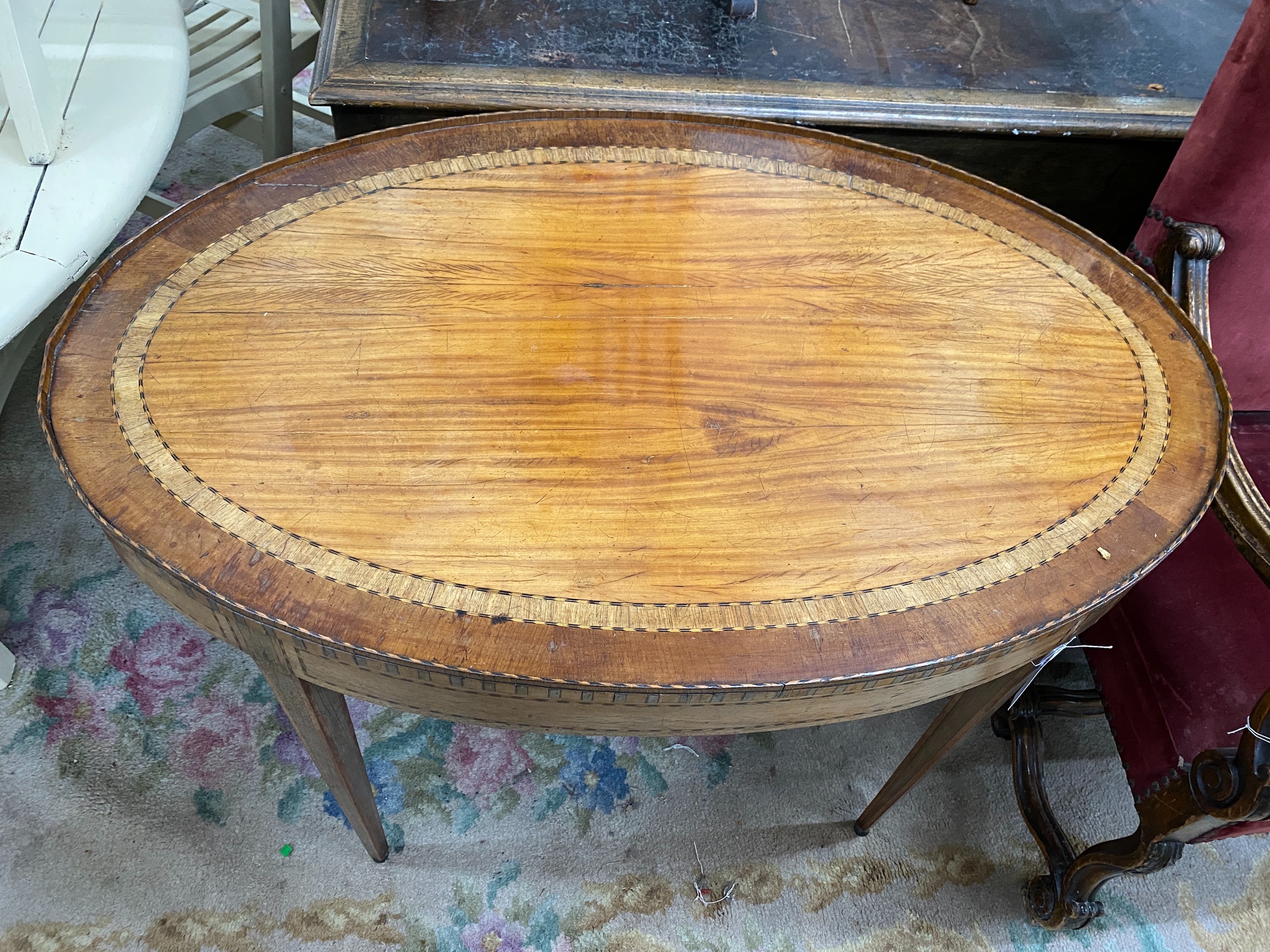 A George III Sheraton style oval banded satinwood centre table fitted drawer on square tapered legs, length 110cm, depth 70cm, height 75cm